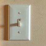 An old North American light switch on a wall near a doorway, highlighting when to call Dustmen Electric for residential troubleshooting and repair.