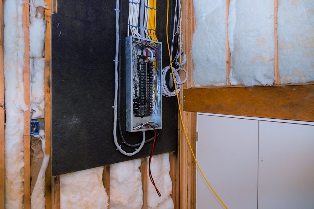 An open electrical control panel box with organized breaker switches, highlighting professional setup and inspection services by Dustmen Electric.