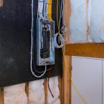 An open electrical control panel box with organized breaker switches, highlighting professional setup and inspection services by Dustmen Electric.